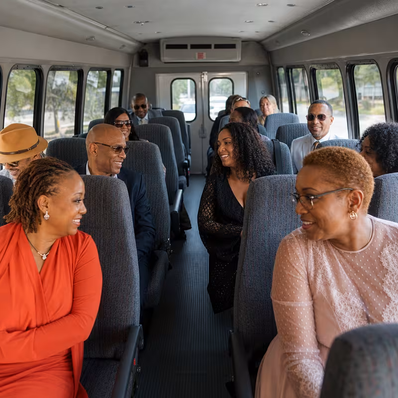 Group boarding a white charter bus for Private Event Transportation transportation in Shreveport
