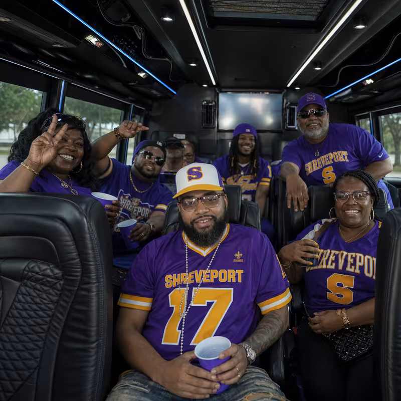 Group boarding a white charter bus for Sporting Event Transportation transportation in Shreveport